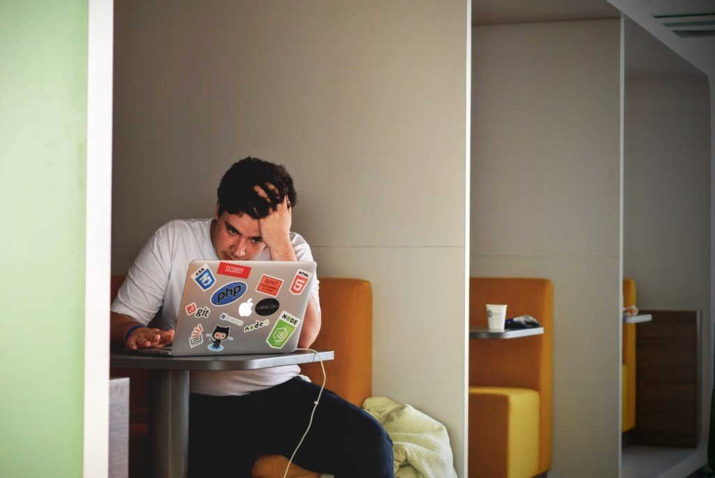 Man working on his laptop and struggling to create content to hit a deadline.