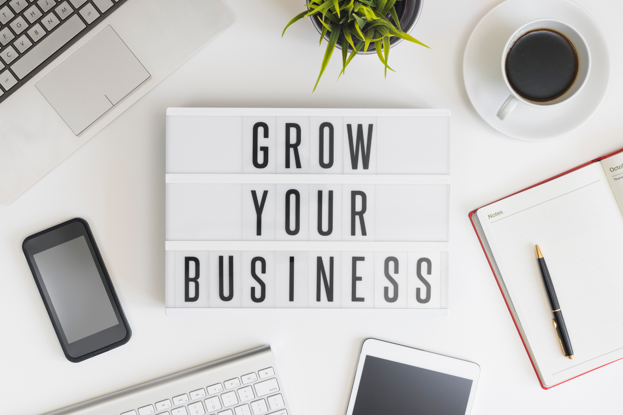"Grow Your Business" sign laying on a work desk.