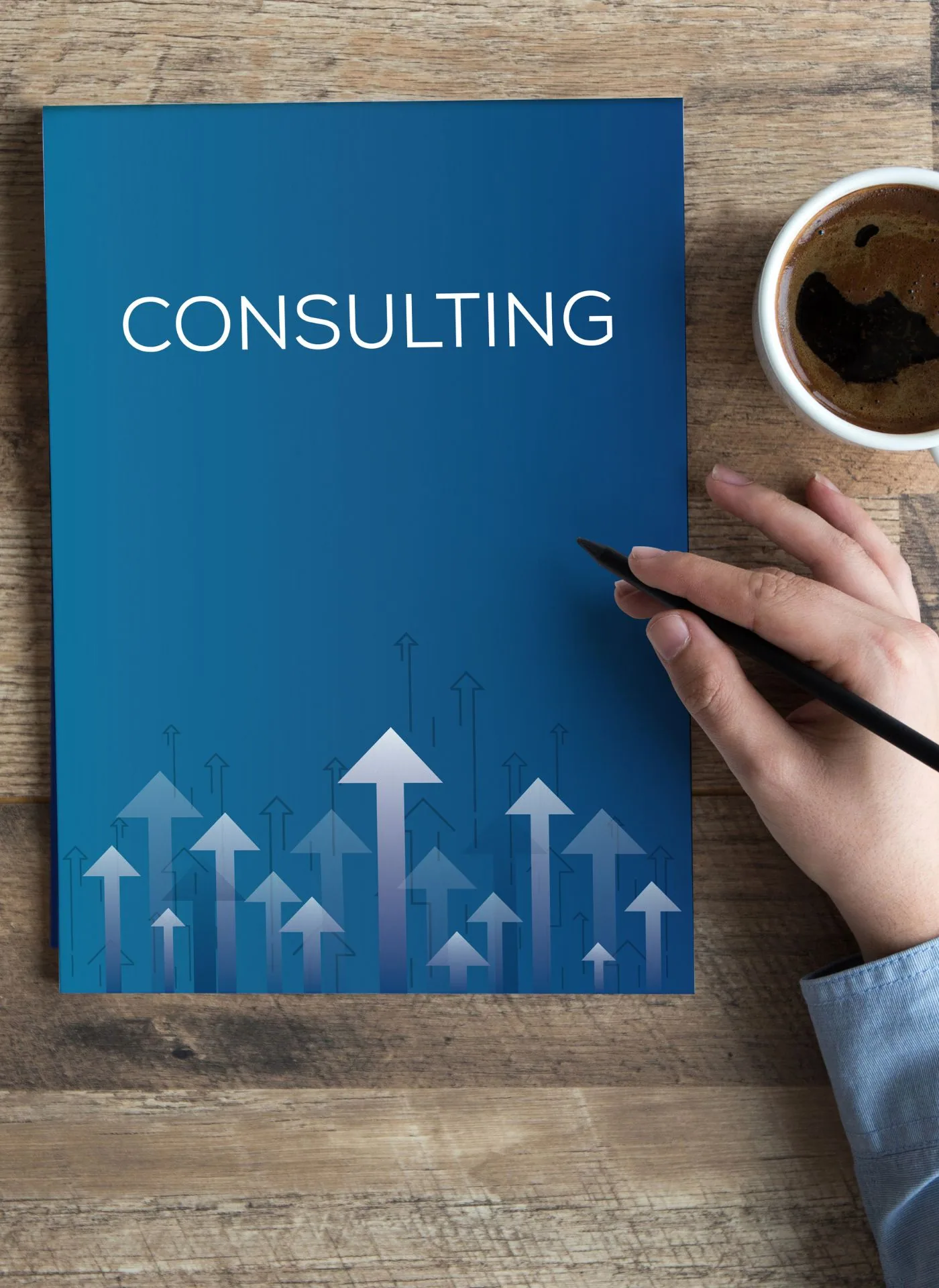 Person holding blue consulting document with upward arrow graphics on wooden desk next to coffee cup