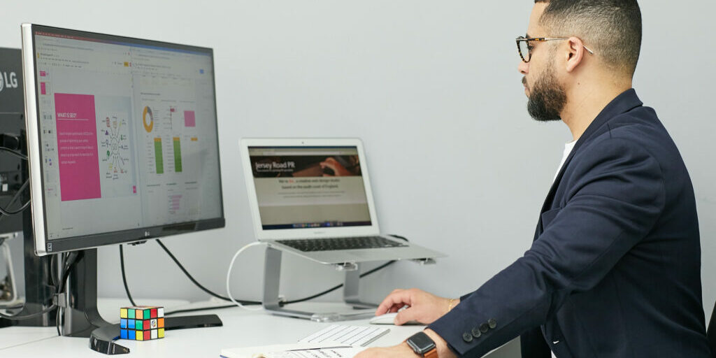 Man sitting at his computer studying SEO and wondering if now is the time to invest in it.