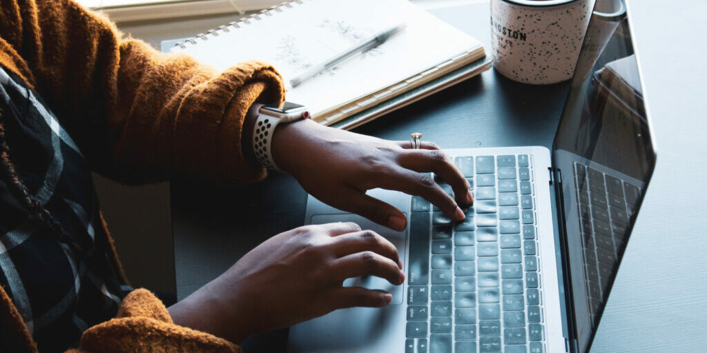 Woman working on her laptop writing blog post titles.