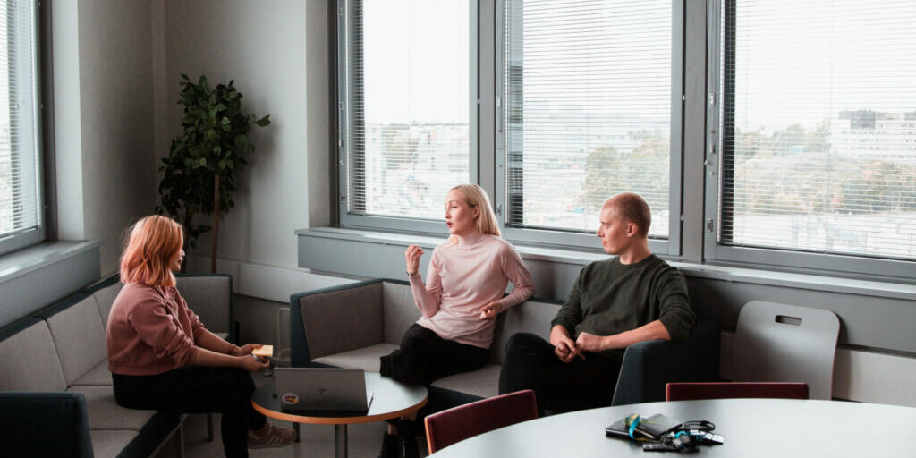 Three people sitting in an office talking about brand-building strategies.