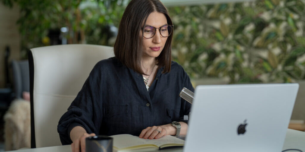 Woman sitting at her laptop creating content marketing campaigns.