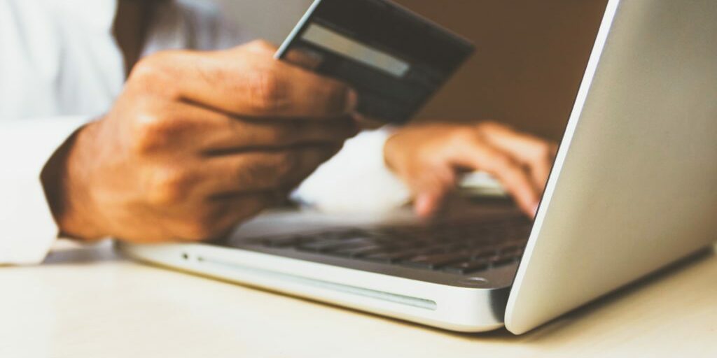 Man looking at his credit card to make an online purchase because of an effective digital content marketing plan.