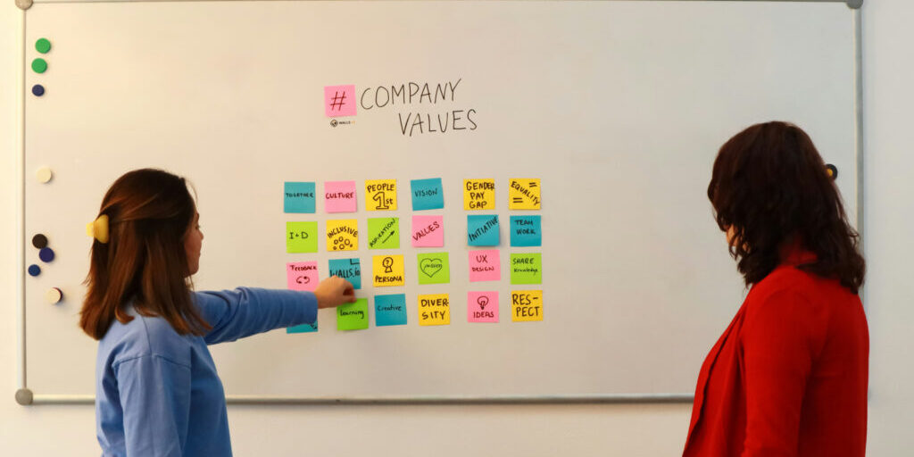 Two women at a white board discussing their employer of choice strategy.