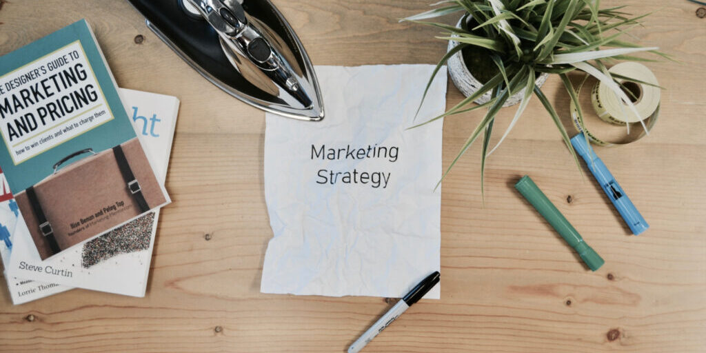 Crumpled paper with the words "marketing strategy" written on it.